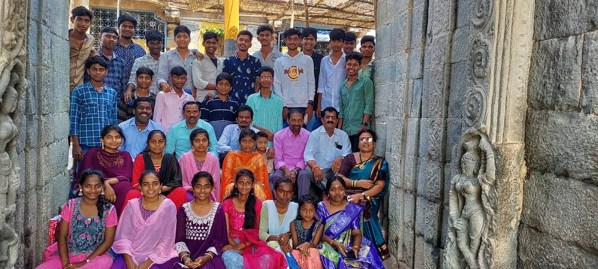 Students and teachers gathered for a group photo in a carved stone temple mandapam