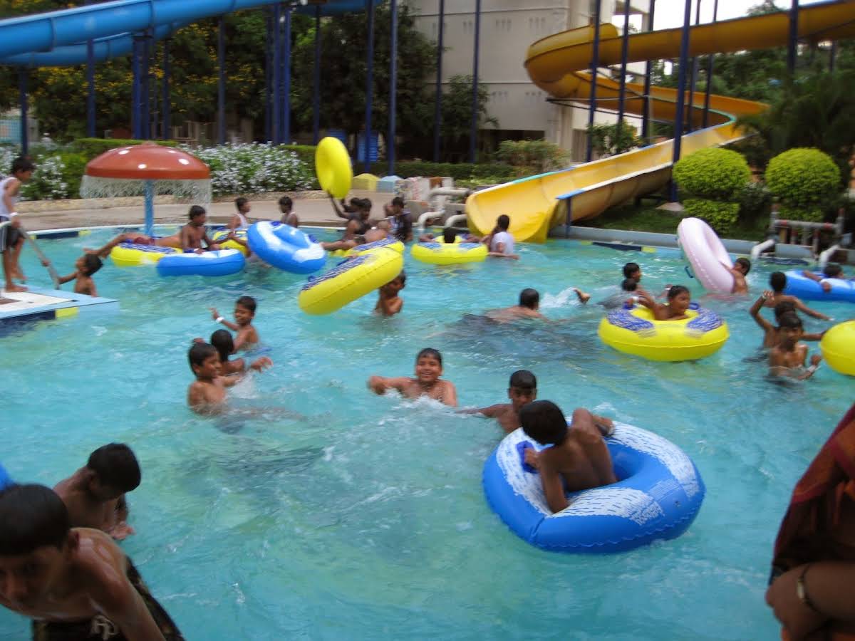 Children playing in the pool with rubber rings on a supervised water-park outing